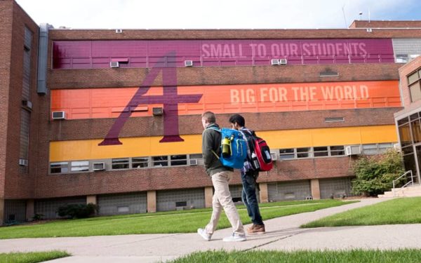 Students walk in front of an Augsburg campus building.